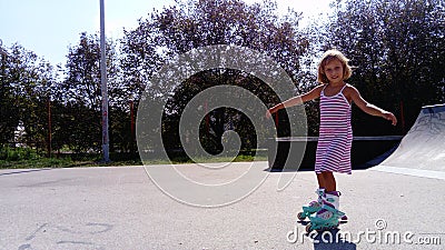 Sremska Mitrovica, Serbia, September 12, 2020. The girl is rollerblading on the asphalt. A 7-year-old child in a striped dress Editorial Stock Photo