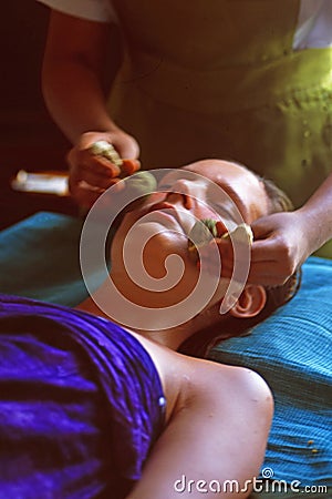 Sri Lanka: A woman enjoying a ayurevedic herbal stamp massage near Unawatuna Editorial Stock Photo