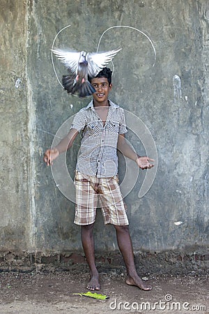 A Sri Lankan boy in Negombo releases his pigeon from its coop. Editorial Stock Photo