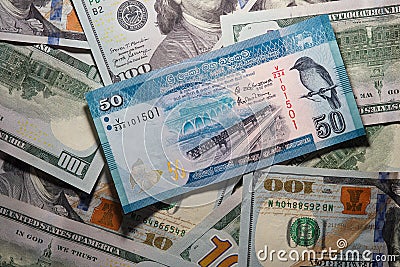 50 Sri Lankan rupees on a background of 100 dollar bills Editorial Stock Photo