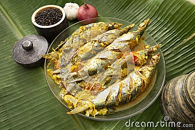 Sri Lankan style Salman fish curry on a Glass plate with spices on a banana leaf Stock Photo