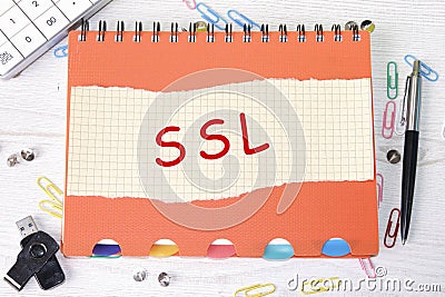 SSL word is written on a sheet in a cage lying on a notebook on the table next to stationery Stock Photo