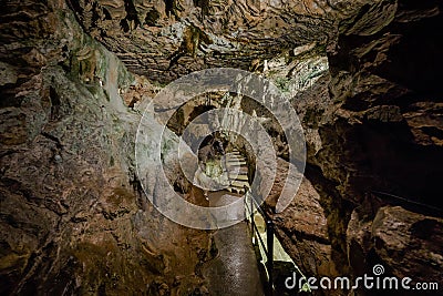 St. Beatus Cave and waterfalls above Thunersee, Sundlauenen, Switzerland. Falls are running down the mountain with a green grass Stock Photo