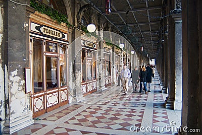 People walk by the passage in front of the windows of the famous Florian cafe at Piazza San Marco in Venice, Italy. Editorial Stock Photo