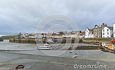 St Monans harbour at low tide with the Fishing houses overlooking the Boats in the Mud. Editorial Stock Photo