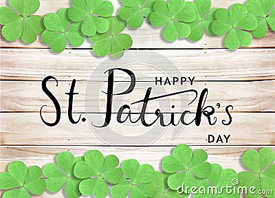 Happy St. Patrick`s Day Black Text Typography Background with Green Shamrocks on Wooden Texture Stock Photo