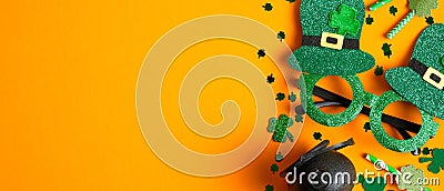 St. Patrick`s day symbols on orange background. Frame border of party glasses, pot of gold, drinking straws. Happy Saint Patricks Stock Photo