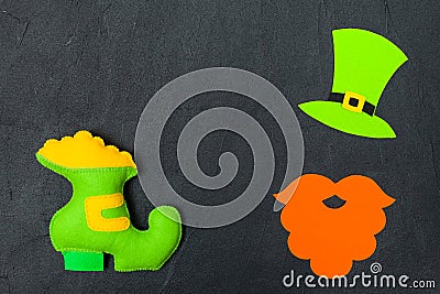 St. Patrick`s Day theme colorful horizontal banner. Green leprechaun hat, beard and shoe with gold on black background. Felt craf Stock Photo