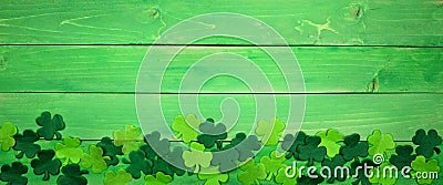 St Patricks Day banner with bottom border of shamrocks, overhead view over a green wood background Stock Photo