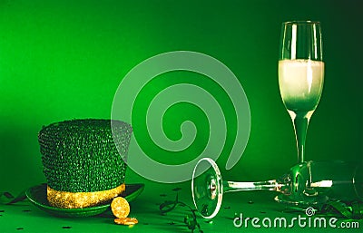 St Patricks Day celebration party image with leprechaun hat, gold coins and champayne on green background Stock Photo