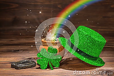 St Patricks day decoration with magic light rainbow pot full gold coins, horseshoe, green hat and shamrock on vintage wooden back Stock Photo
