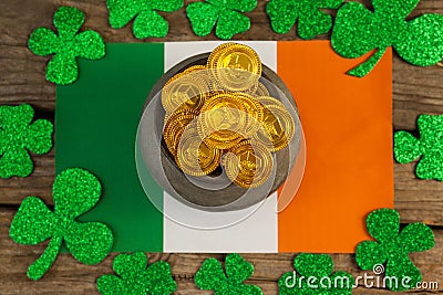 St. Patricks Day pot of chocolate gold coins and irish flag surrounded by shamrock Stock Photo