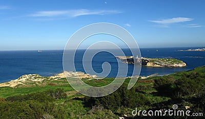 ST PAUL\'S BAY, MALTA - Feb 10, 2014: St Paul\'s Islands, off the coast of Malta, with a statue of St Paul on top, and fish farms Stock Photo