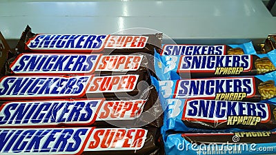 Chocolate bars Snickers Super on supermarket shelf. Sweet food. Retail industry. Shelves with sweet food. Store. Grocery shopping Editorial Stock Photo