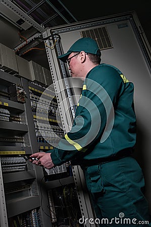 Electrician engineer is testing electrical equipment at a large plant. Editorial Stock Photo