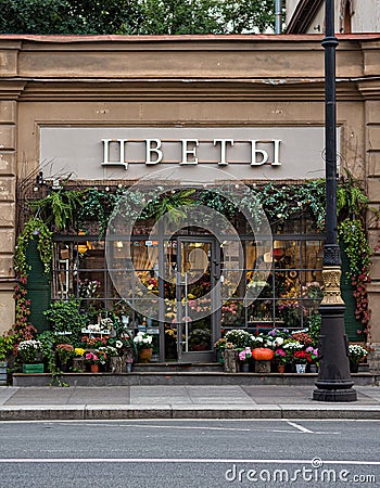 St. Petersburg, Russia - June 5, 2019, a beautiful facade of a flower shop with a bright sign and a window decorated with plants a Editorial Stock Photo