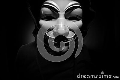 St. Petersburg - Russia - 25 December 2019 - Anonymous person in Guy Fawkes mask on black background Editorial Stock Photo