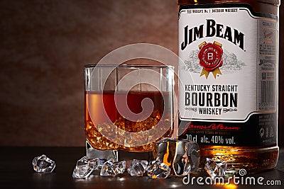 St.Petersburg, Russia - December 2019 - Bottle of Jim Beam bourbon whiskey and glass with drink and ice on brown background Editorial Stock Photo