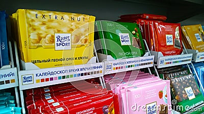 Shelves with various famous brand chocolate Ritter Sport. Candy with nuts. Aisle in supermarket. Promotion. Retail industry. Editorial Stock Photo