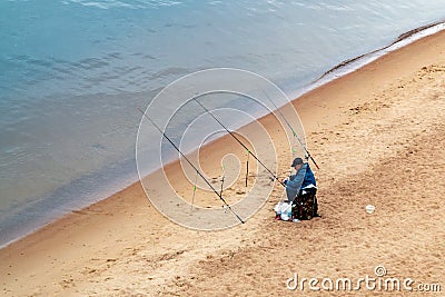 St. Petersburg, Russia - July 10, 2018: fisherman are fishing on the sandy shores of the Gulf of Finland under the bridge Editorial Stock Photo