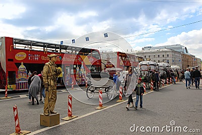 02.09.2020 St. Petersburg Russia. Red bus for excursions. White horses, carriages and a golden man-monument. urban tourism Editorial Stock Photo