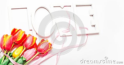 St. Valentine or Mother`s Day. Beautiful tulips, pink ribbon on light background. Day of birth. Greeting card Stock Photo