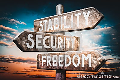 Stability, security, freedom - wooden signpost, roadsign with three arrows Stock Photo