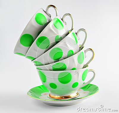 A stack of antique ceramic cups on a saucer on a white background. Stock Photo