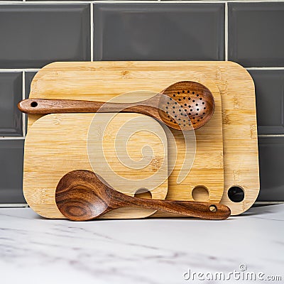 stack of bamboo chopping boards and teak hardwood spoons Stock Photo