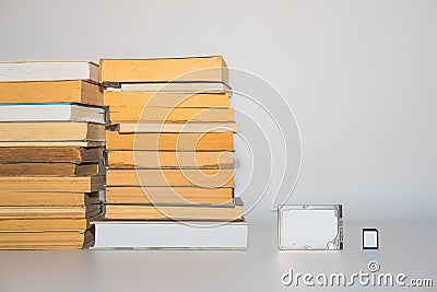 Stack of books, hard disk drive and memory card, development of technology and storing capacity. Stock Photo