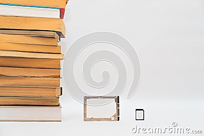 Stack of books, hard disk drive and memory card, improving technology. Stock Photo