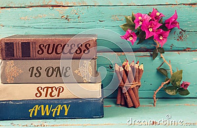 Stack of books over wooden table and motivational phrase Stock Photo