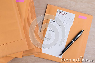 Stack of bubble wrap padded mailing envelopes and pen on white b Stock Photo