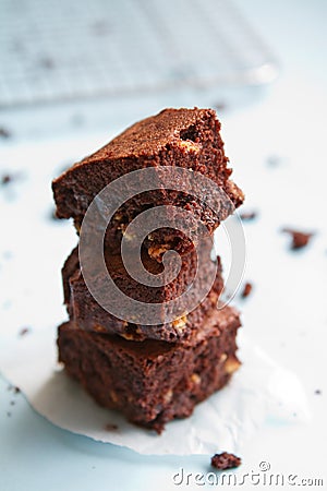 Stack of chocolate brownies on pastel blue background Stock Photo