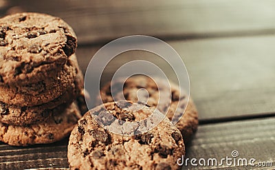 A stack of chocolate chip cookies lies on a wooden table. Rustic table. Vintage toning. Dietary useful cookies without gluten. Stock Photo