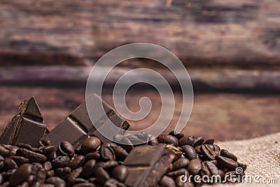 Stack of chocolate chunks with coffee beans on a wooden background, horizontal with copy space Stock Photo