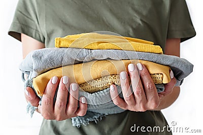 Stack of clothes in woman s hands on white background isolation Stock Photo