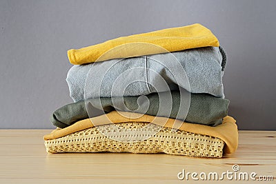 Stack of clothes on wooden table and grey background isolation Stock Photo
