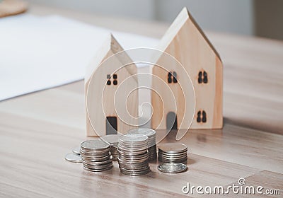 Stack of coins money with wood house model on table, Business Growth concept, Financial risk. for plan saving finance and banking Stock Photo