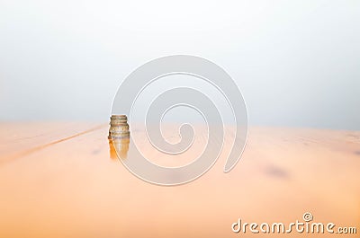 Stack of coins on reflecting pine wood table , conceptual image of macro economy Stock Photo