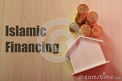 Stack of coins and toy model house with text ISLAMIC FINANCING Stock Photo