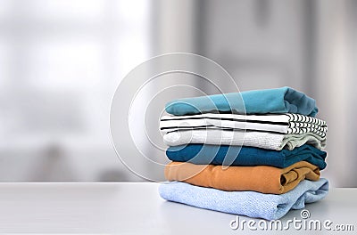 Stack of colorful clothes. Pile of clothing on table empty space background Stock Photo