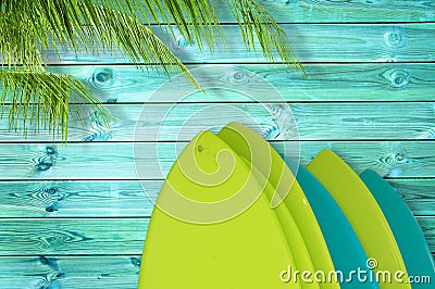 Stack of colorful surfboards on a tropical blue wood planks background with palm tree Stock Photo