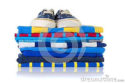 Stack of colourful summer shirts and a pair of sneakers on top i Stock Photo