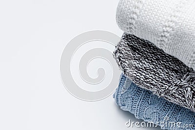 Stack of cozy comfortable homely clean washed knitted pullovers in pastel colors, laundry and washing clothes concept. White Stock Photo