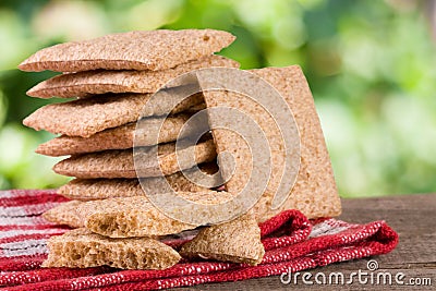 Stack of crisp bread on a wooden table with blurred garden background Stock Photo