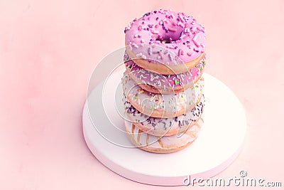 Stack of Delicious Beautiful Donuts on Pink Background Wooden Tray Pink Lilac and White Donuts Copy Space Vertical Photo Toned Stock Photo