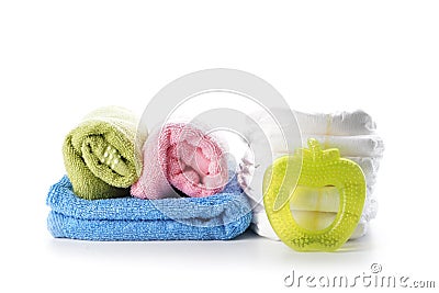 Stack of diapers with towels and baby teether on white background Stock Photo