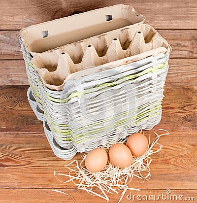 Stack of empty pulp egg cartons and several chicken eggs Stock Photo
