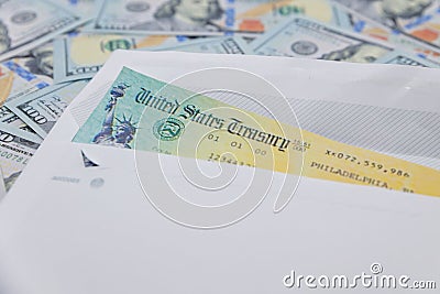 Stack of 100 dollar bills with coronavirus stimulus payment check to show the virus payment to Americans. Concept IRS tax refund Editorial Stock Photo
